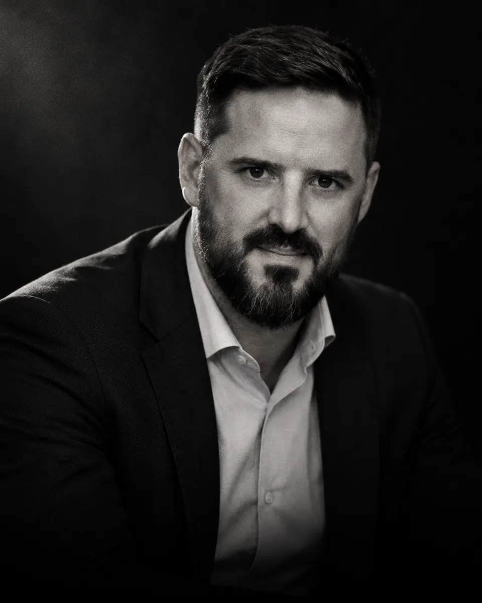 Portrait de Cédric Martins en noir et blanc, veste sombre et chemise claire